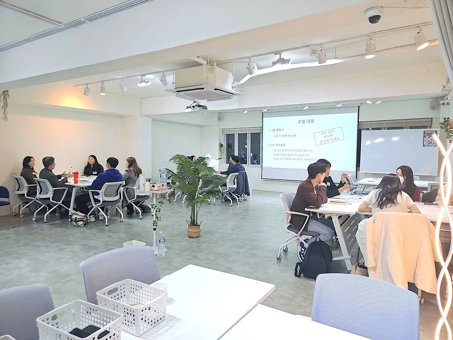 조별 테이블로 세팅된 메인홀 전경 — 워크샵 팀 활동 배치